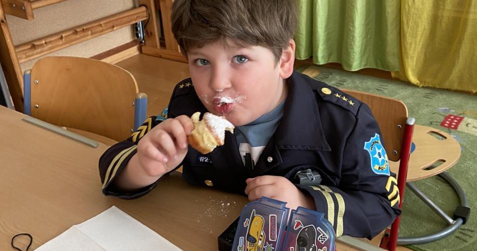 Kind isst Faschingskrapfen